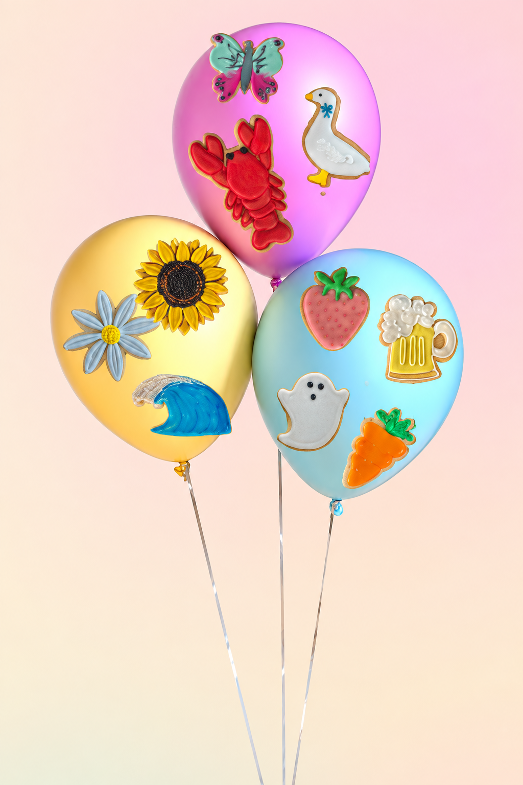 Three pastel balloons decorated with hand-iced celebration biscuits